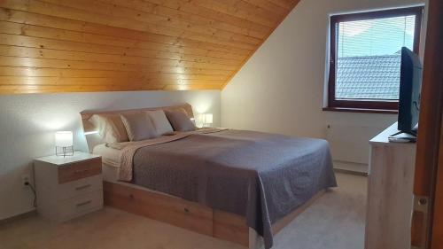 a bedroom with a bed and a flat screen tv at Holiday house Erika in Stará Lesná
