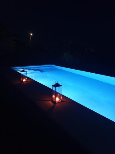 two lights on the side of a swimming pool at night at Villa Leonidas in Anavissos