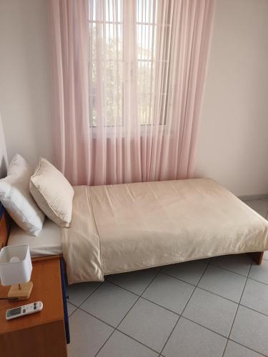 a bed sitting in a room with a window at Villa Leonidas in Anavissos