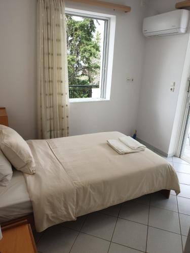 a bedroom with a large bed with a window at Villa Leonidas in Anavissos