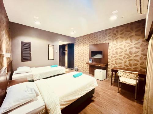 une chambre d'hôtel avec deux lits et un bureau dans l'établissement City Hotel Balikpapan, à Klandasan-besar