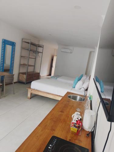 a room with a bed and a kitchen with a table at Triple 8 Suites in Labuan Bajo