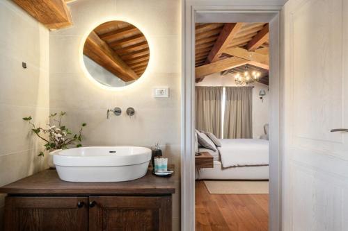 a bathroom with a white sink and a bedroom at Villa Paladnjaki - breakfast included in Žminj