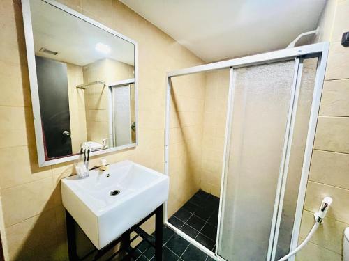 une salle de bain avec un lavabo et une douche dans l'établissement City Hotel Balikpapan, à Klandasan-besar