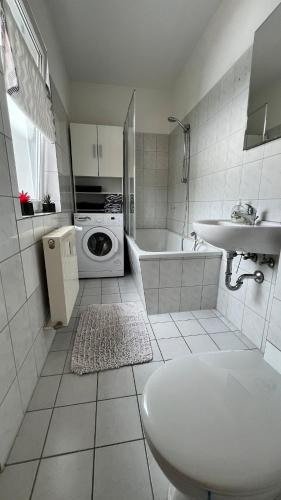 a white bathroom with a sink and a washing machine at Apartment-Luck Ilmenau in Ilmenau