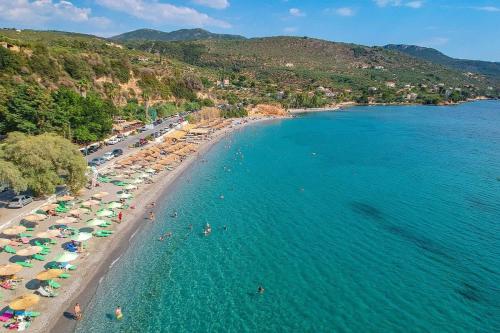 an aerial view of a beach with people and umbrellas at Avia's Seaside Hideaway with Lush Garden in Avia