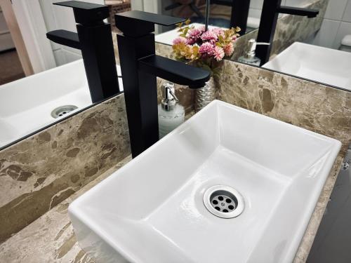 ein weißes Waschbecken im Badezimmer mit zwei Spiegeln in der Unterkunft Flat Aquaville perto do Beachpark com 3 Suites in Aquiraz