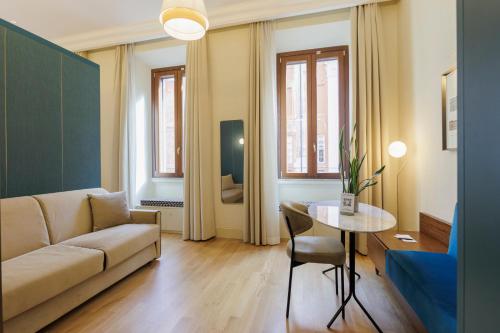 a living room with a couch and a table at Sentho Roma in Rome
