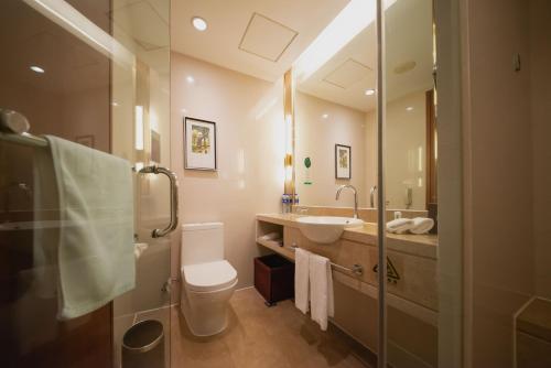 a bathroom with a sink and a toilet and a mirror at Holiday Inn Xiaoshan by IHG in Hangzhou