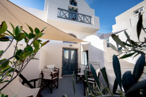 a patio with chairs and a door in a building at Lotza Studios in Oia