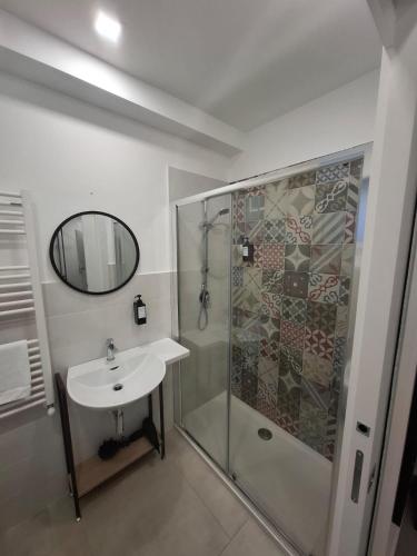 a bathroom with a shower and a sink and a mirror at sikelia rooms in Viagrande