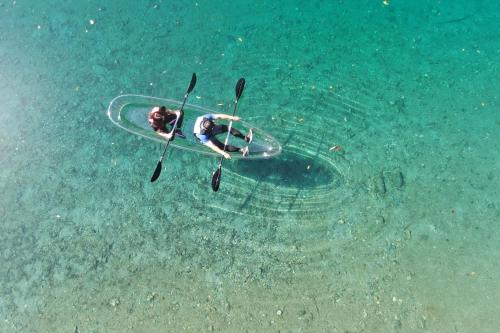 a person laying on a surfboard in the water at KAMENOI HOTEL Kochi in Ino