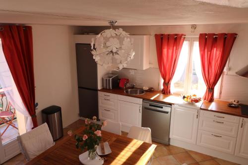 a kitchen with a table and red curtains and a table and a tableablish at Marie à Callas in Callas
