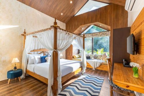 a bedroom with a canopy bed and a window at 3-BHK Retreat with Picturesque Balcony & Patio in Rājpur