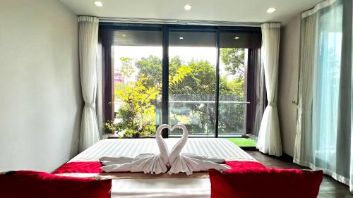 a swan decoration on a bed in front of a window at Civic Horizon Hotel & Residence in Bangkok