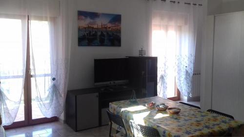 a dining room with a table and a television at Villa Elena in Minturno