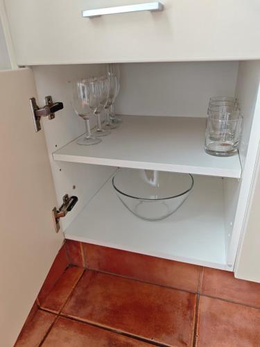 a white cabinet with wine glasses on it at Great Lake Motel Taupo in Taupo