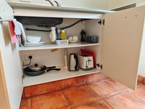 a kitchen with an open pantry with utensils at Great Lake Motel Taupo in Taupo