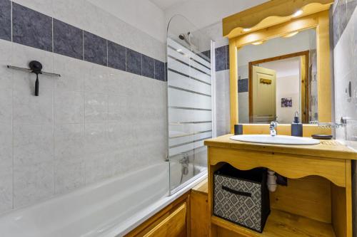 une salle de bain avec un lavabo, une baignoire et un miroir dans l'établissement Résidence Les Hauts De Preclaux - Appartement exposé sud au coeur des Orres 1800 MAE-1651, aux Orres