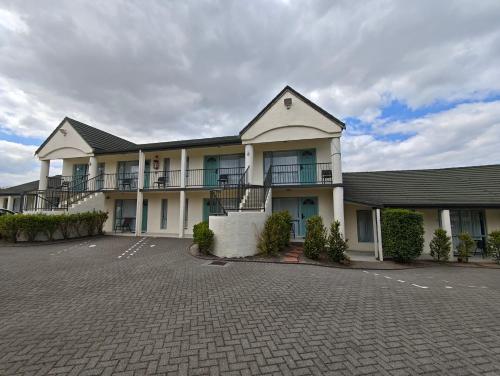 a building with a parking lot in front of it at Great Lake Motel Taupo in Taupo