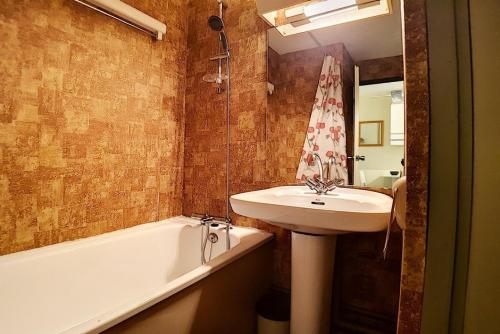 une salle de bain avec un lavabo et une baignoire dans l'établissement Résidence Astragales - Studio cabine classique · Proche des pistes MAE-1671, aux Menuires