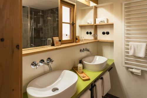 a bathroom with two sinks and a mirror at Hotel Oberstdorf in Oberstdorf