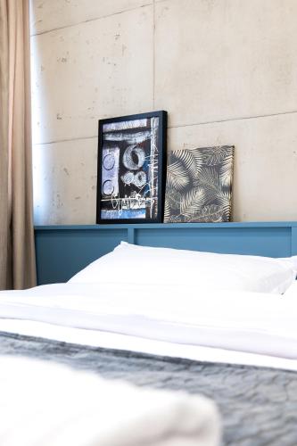 a bedroom with a bed and a picture on a shelf at AL Apartments Tirana in Tirana