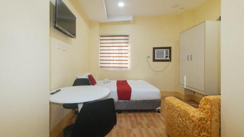 a room with a bed and a table and chairs at RedDoorz at Casa Barcelona Condotel in Iloilo City