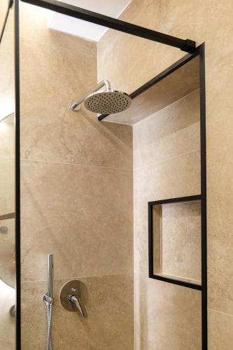 a shower with a shower head in a bathroom at AL Apartments Tirana in Tirana