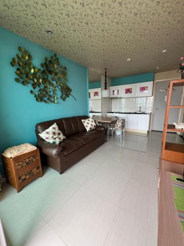 - un salon avec un canapé brun et un mur bleu dans l'établissement Atlantis Condo Resort Pattaya, à Jomtien Beach