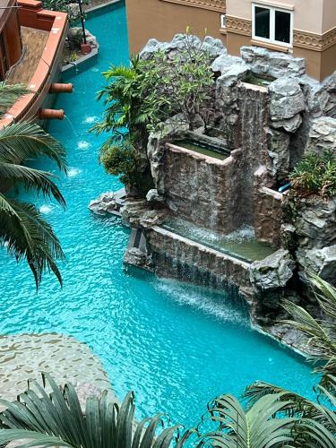 un toboggan aquatique dans un complexe hôtelier avec une cascade dans l'établissement Atlantis Condo Resort Pattaya, à Jomtien Beach