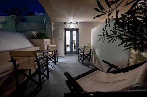 a room with a bed and a table and chairs at Lotza Studios in Oia