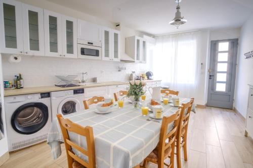 une cuisine avec une table et des chaises ainsi qu'un lave-linge. dans l'établissement Maison Charmante au coeur de la circulade-Patio-AB, à Bram
