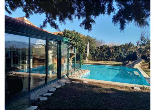une maison avec une piscine aux parois en verre dans l'établissement Magnifique maison Piscine et Spa 5mins des plages, à Elne