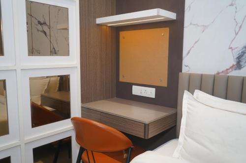 a bedroom with a bed and a chair and a mirror at Abssolute Homtel - Rooms & Suites in Pune