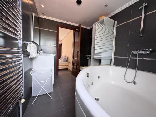 a bathroom with a white tub and a sink at VILLA San Juan PLAYA Alicante in El Campello