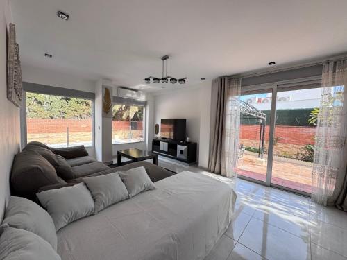 a living room with a couch and a large window at VILLA San Juan PLAYA Alicante in El Campello