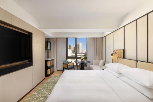 a hotel room with a large bed and a flat screen tv at 昆明开臣Kasion酒店 in Kunming
