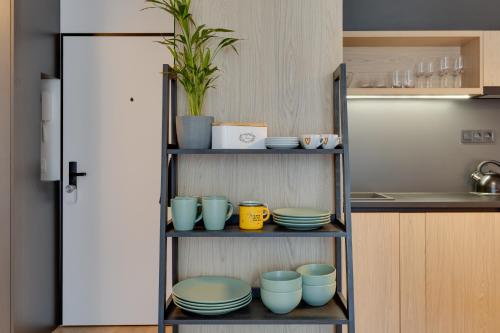 a shelf with bowls and plates on it in a kitchen at Apartmán Galileo in Trnava