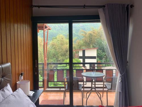 a bedroom with a view of a balcony with a table at Gubuk Ndeso Bromo in Bromo