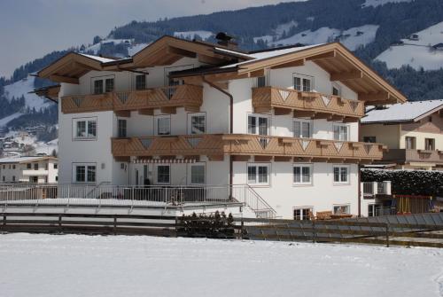 ein großes Gebäude mit Schnee davor in der Unterkunft Appartements Olympia in Mayrhofen
