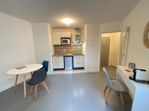 une petite cuisine avec une table et des chaises dans une pièce dans l'établissement Petit Mayence - Studio hyper-centre au calme, à Nantes