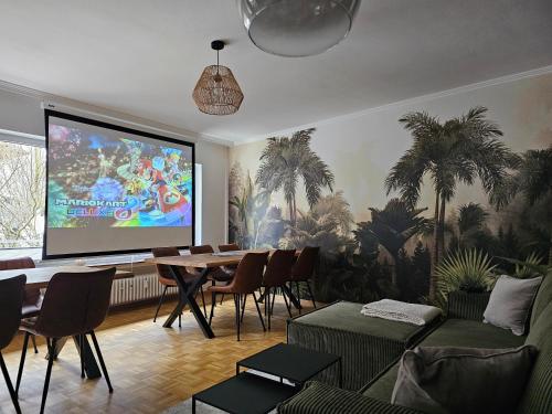 a living room with a table and a projection screen at Heritage - Perfekt für Gruppen, 15min Willingen in Brilon