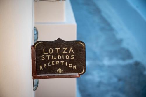 a sign on the side of a building at Lotza Studios in Oia