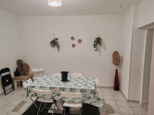 une table et des chaises dans une pièce avec un mur blanc dans l'établissement Les 3 Frontières 1 Luxembourg, à Herserange