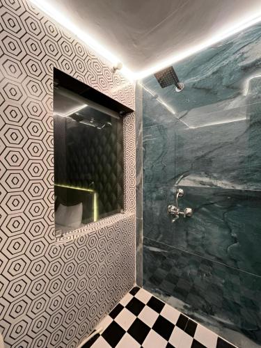 a bathroom with a shower with a mirror and a sink at The First Floor I Top Rated Boutique Homestay I Near Lekhraj Metro Lucknow in Lucknow