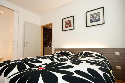 a bedroom with a black and white comforter on a bed at @Cocoon in Ypres