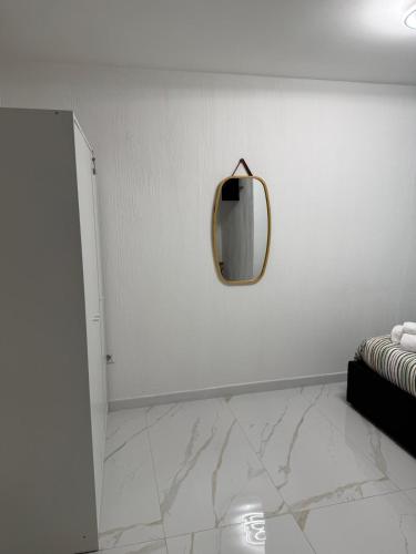 a mirror on a white wall in a room at A Casa di JO in Bari