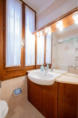 a bathroom with a sink and a toilet and a mirror at Alla Corte Rossa in Venice