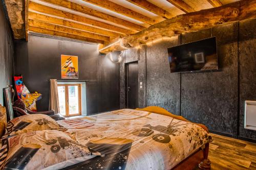 a bedroom with a bed in a room with wooden ceilings at Cinéma Room - Salle vidéo projecteur - Netflix in Chicheboville